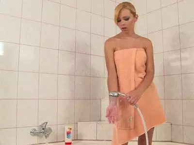 Die rasierte Möse wird mit dem Wasserstrahl massiert bis sie feucht ist